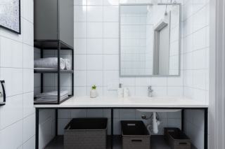 Salle de bain au style industriel : verrière à croisillons, robinetterie noire et plan de vasque en bois